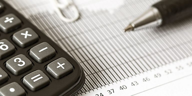 Close-up Photograph of a Calculator and a Graph Paper, representing the IRS