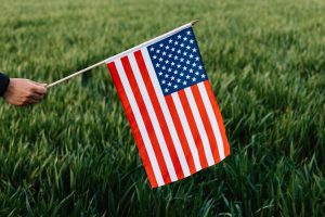 Crop anonymous patriot showing flag of United Stated of America