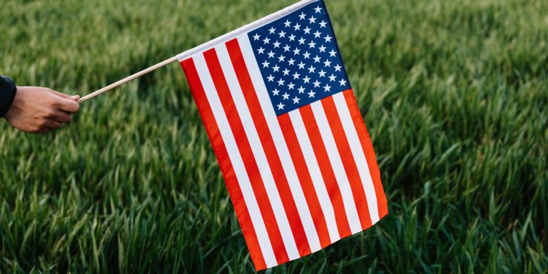 Crop anonymous patriot showing flag of United Stated of America