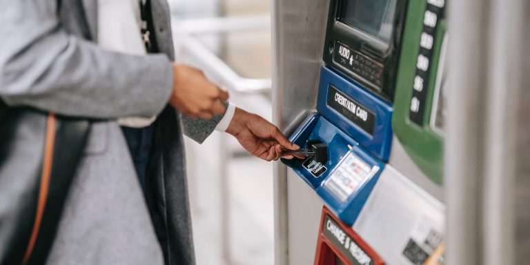 Close-up of person inserting bank card into ATM