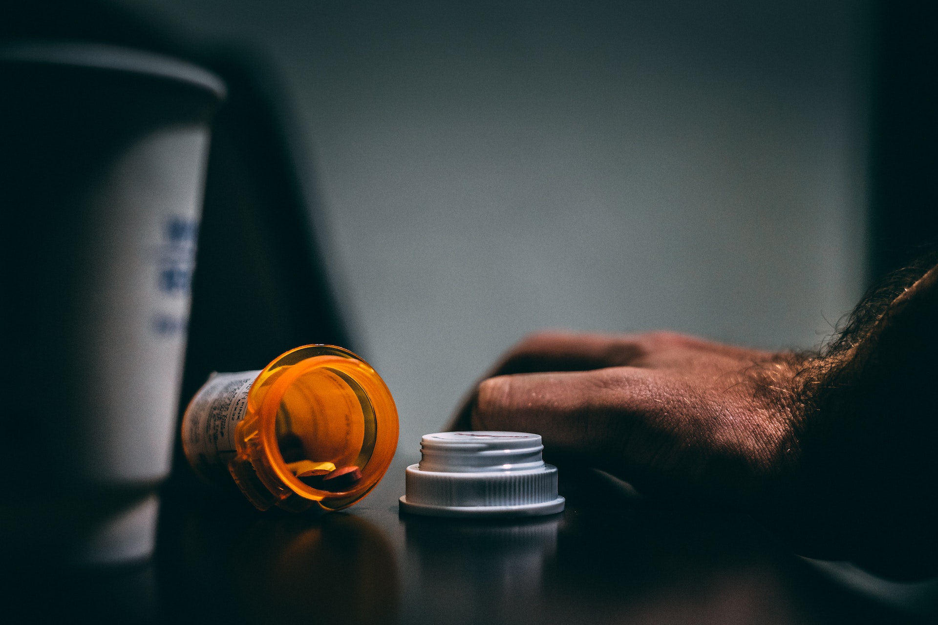 Orange and White Prescription Bottle On Table, suggesting the opioid epidemic