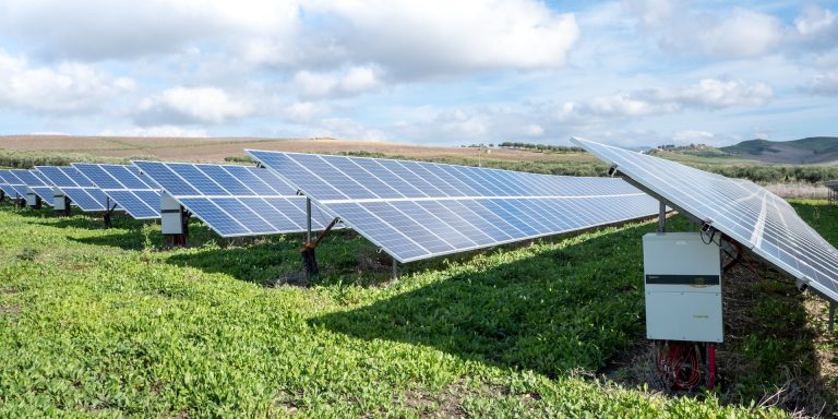 Photovoltaic PV plant ground mounted with string inverters, highlighting clean energy fraud