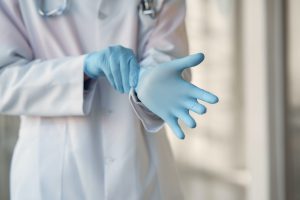Person Wearing Blue Sterile Gloves - setting a good example, representing healthcare fraud
