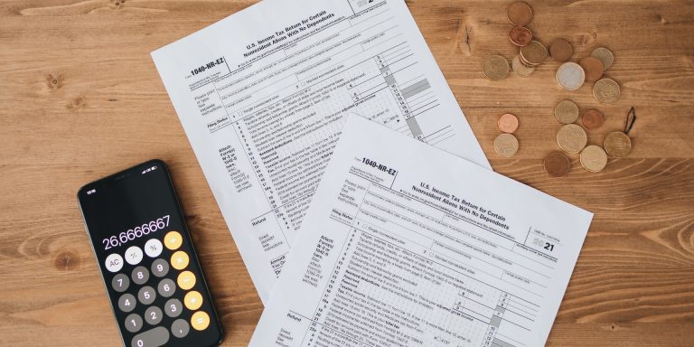 A Papers with Coins and Mobile Phone on the Side, representing whistleblower contracts