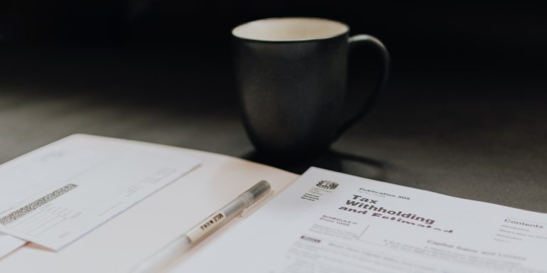 Accounting pages and a coffee mug, representing internal and external audits