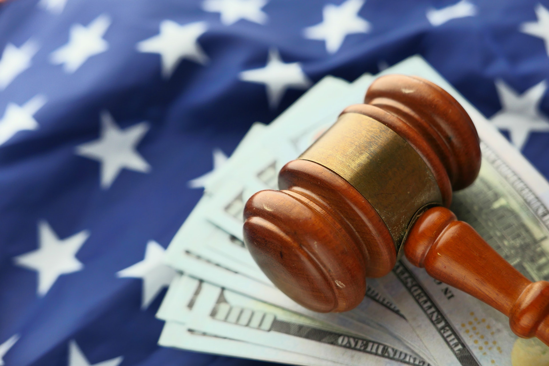 Gavel on top of money and a flag, representing Whistleblower Client Rewarded