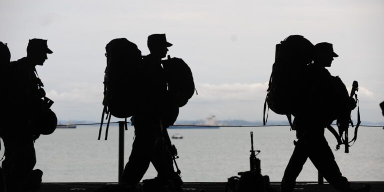 Silhouette of Soldiers Walking, representing military contractors