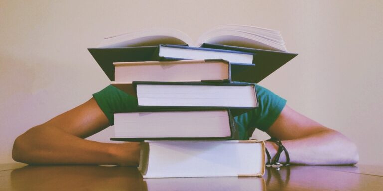 Student Behind Stack of Books