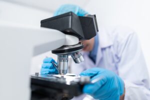 Closeup of Scientist Looking Through Microscope in a Lab - for article on Novartis