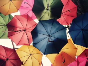 Sea of colorful umbrellas, representing insurance coverage and insurance fraud.