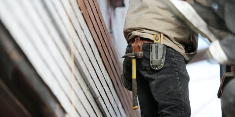 Man Wearing Black Denim Pants With Carrying Hammer on Holster