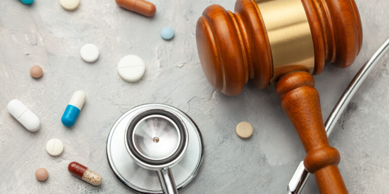 Judge gavel and stethoscope with pills. Exposing Fraud in Specialty Pharmacies and PBMs