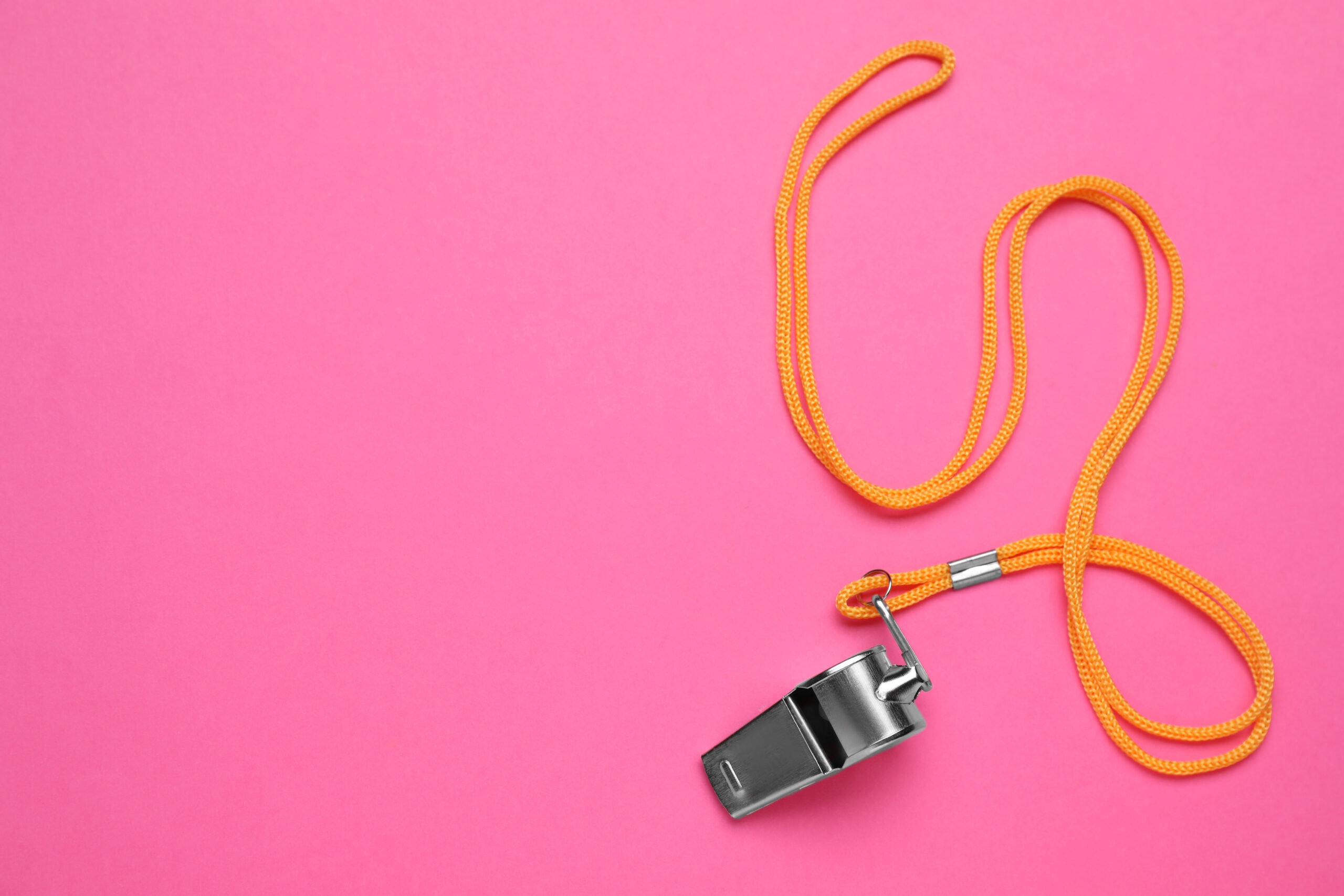 One metal whistle with cord on pink background, top view, representing a whistleblower for Ozempic Fraud