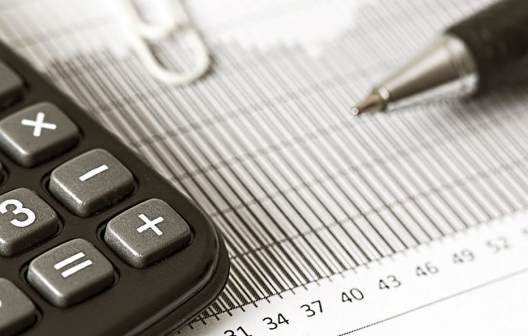 Close-up Photograph of a Calculator and a Graph Paper, representing the IRS